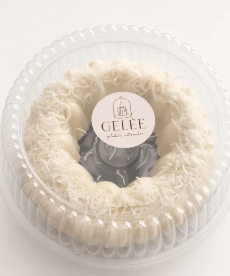 Gelée grande sabor coco, en forma de rosca cubierta de coco rallado, dentro de su envase redondo