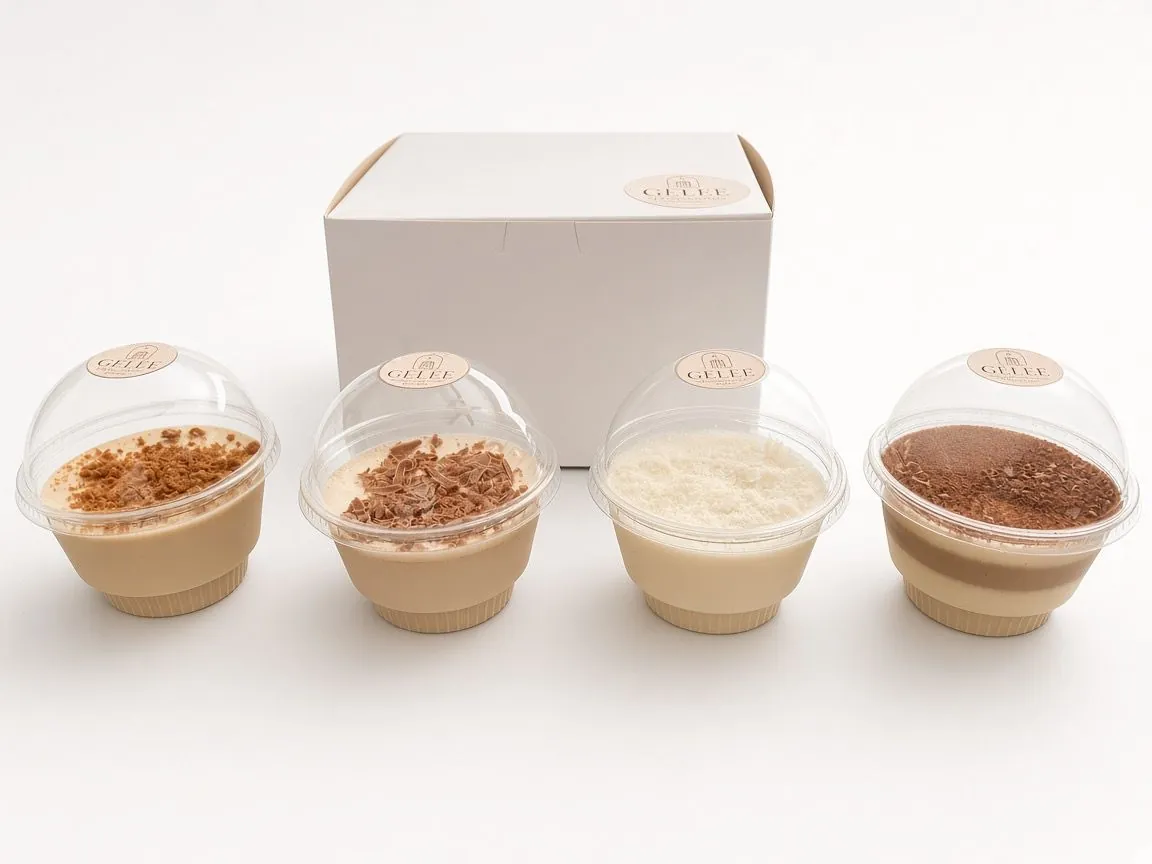 Los cuatro sabores de GELÉE en vaso individual, alineados frente a la caja de la marca